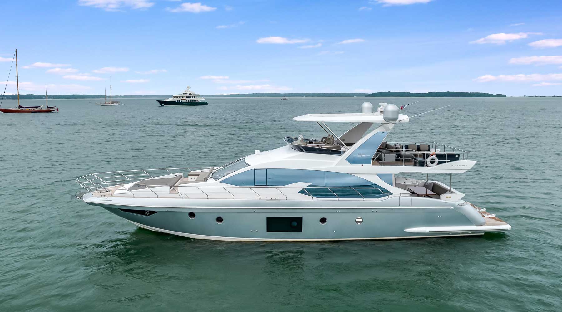 A motorboat of Toronto Yachts,gently floats on the calm water of lake ontario, reflecting the surrounding scenery.